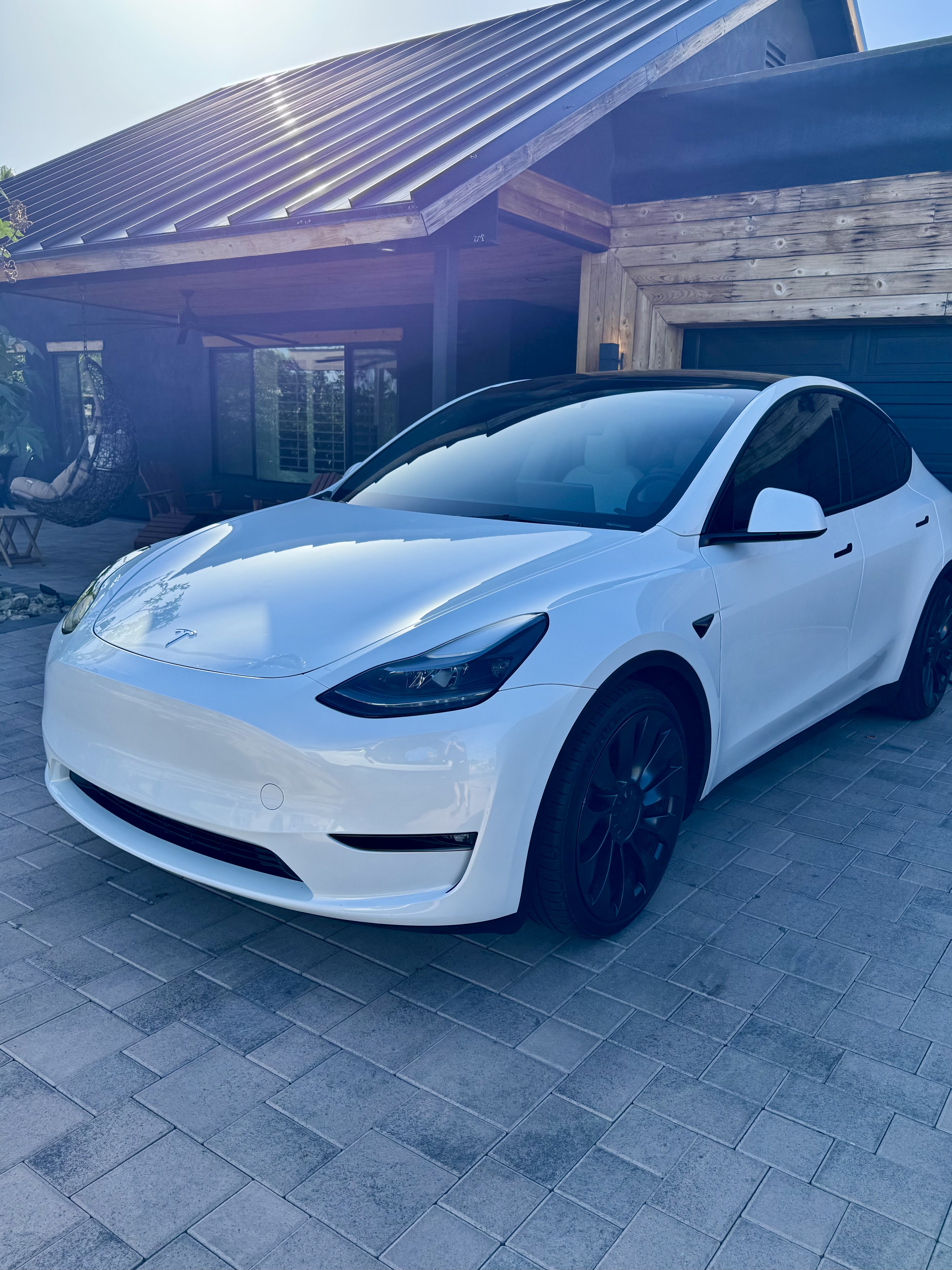 Tesla Model Y — Pearl White, paver driveway